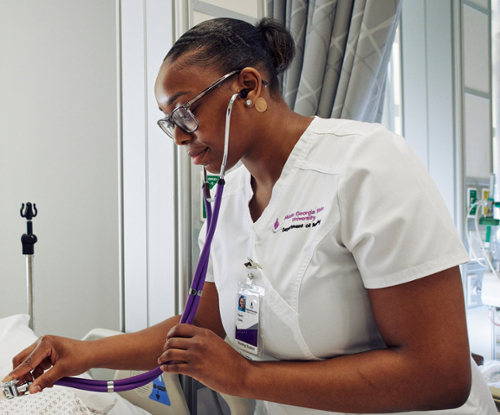 MGA nursing student practicing patient vitals during lab.